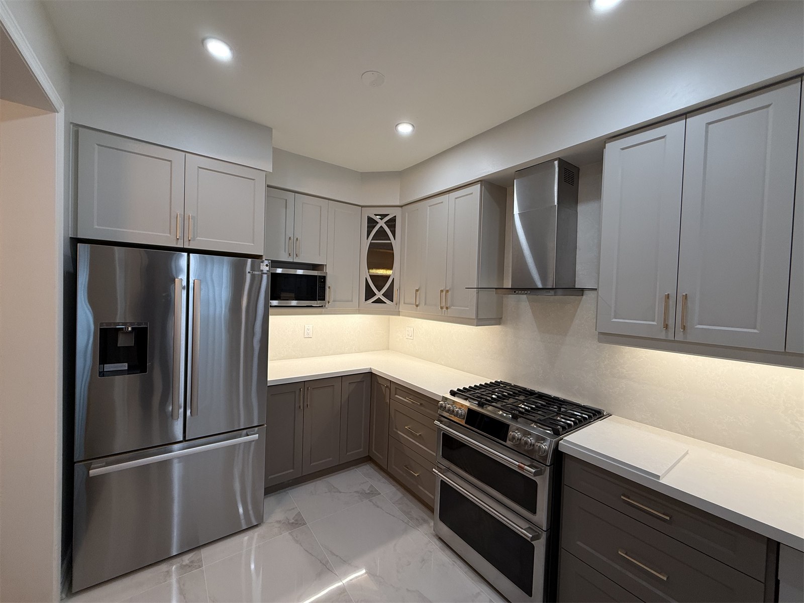 Oakville kitchen corner detail with refrigerator, cooktop, and surrounding cabinetry